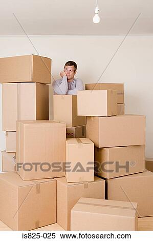 Stock Photography - Man with stack of cardboard boxes. Fotosearch