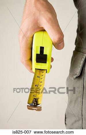 Person holding a tape measure View Large Photo Image Stock Photo - Person holding a tape measure. Fotosearch