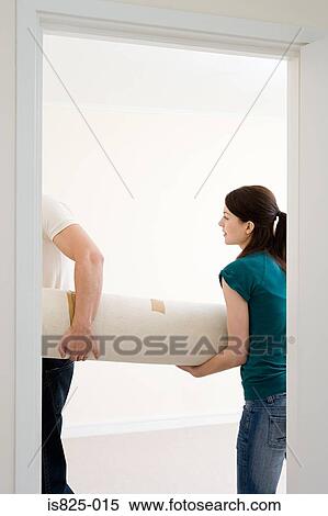 Stock Photography - Woman and man holding rug. Fotosearch