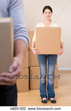 Stock Image - Woman holding cardboard box. Fotosearch
