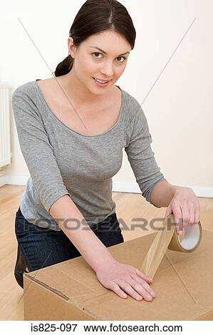 Woman taping up box View Large Photo Image Stock Photo - Woman taping up box. Fotosearch