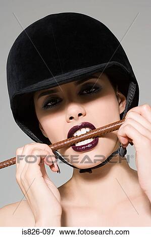 Woman biting a riding crop View Large Photo Image Stock Photo - Woman biting a riding crop. Fotosearch