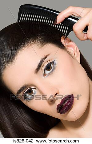 Woman combing her hair View Large Photo Image Stock Image - Woman combing her hair. Fotosearch