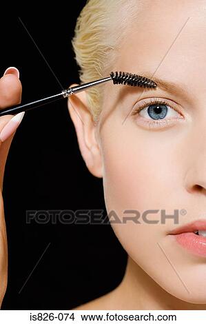 Woman grooming her eyebrow View Large Photo Image Picture - Woman grooming her eyebrow. Fotosearch