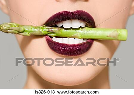 Woman in asparagus in her mouth View Large Photo Image Stock Image - Woman in asparagus in her mouth. Fotosearch