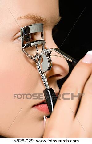 Stock Photo - Woman using eyelash curlers. Fotosearch