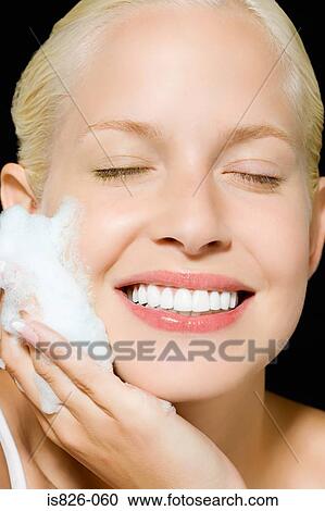 Stock Image - Woman washing her face. Fotosearch
