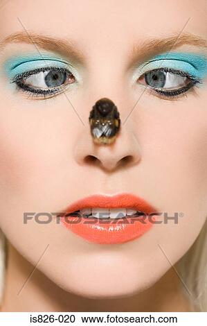 Woman with a bee on her nose View Large Photo Image Stock Image - Woman with a bee on her nose. Fotosearch