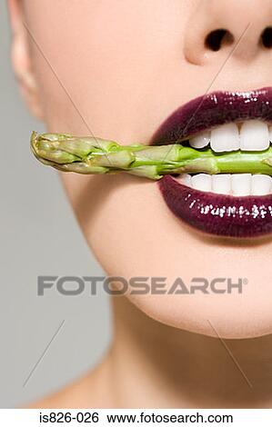 Stock Photograph - Woman with asparagus in her mouth. Fotosearch