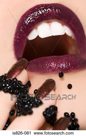 Woman with caviar on her mouth and fingers View Large Photo Image Stock Image - Woman with caviar on her mouth and fingers. Fotosearch