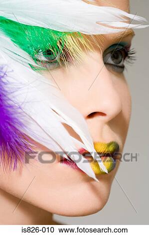 Stock Image - Woman with feathers on her face. Fotosearch