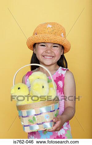 Stock Photograph - Girl holding a basket of chicks. Fotosearch