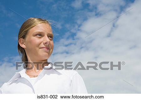 Stock Image - Girl against cloudy sky. Fotosearch