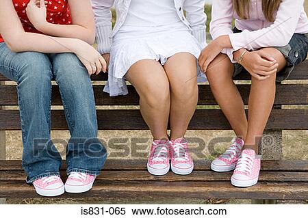 Stock Photography - Girls sitting on bench. Fotosearch