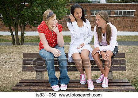 Stock Image - Girls talking on bench. Fotosearch