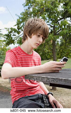 Stock Photography - Teenage boy looking at cellphone. Fotosearch