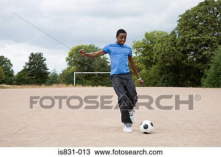 Stock Image - Teenage boy playing football. Fotosearch