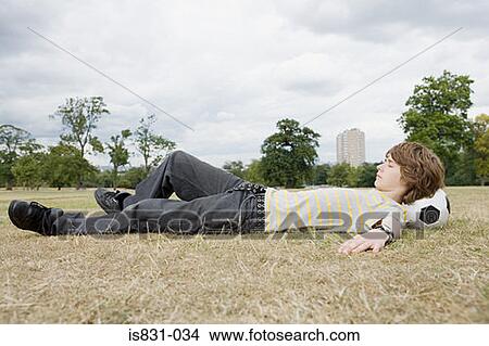 Teenage boy resting on football View Large Photo Image Picture - Teenage boy resting on football. Fotosearch