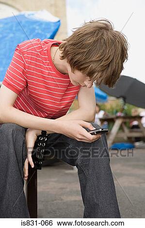 Teenage boy with cellphone View Large Photo Image Stock Photograph - Teenage boy with cellphone. Fotosearch