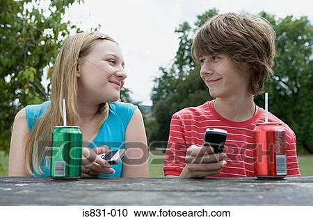 Teenage couple with cellphones View Large Photo Image Stock Image - Teenage couple with cellphones. Fotosearch