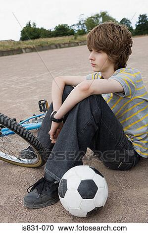 Stock Image - Teenager with bike and football. Fotosearch