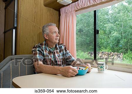 Man having breakfast in a caravan View Large Photo Image Picture - Man having breakfast in a caravan. Fotosearch
