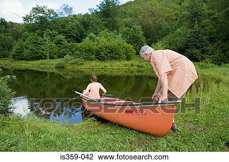 Stock Image - Mature couple canoeing. Fotosearch