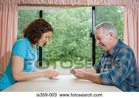 Stock Image - Mature couple playing cards. Fotosearch
