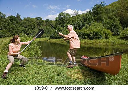 Mature couple playing with oars View Large Photo Image Stock Photo - Mature couple playing with oars. Fotosearch