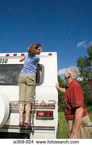 Picture - Mature couple preparing caravan for journey. Fotosearch