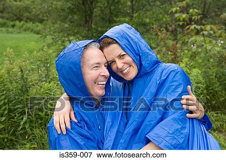 Stock Photo - Mature couple wearing raincoats. Fotosearch