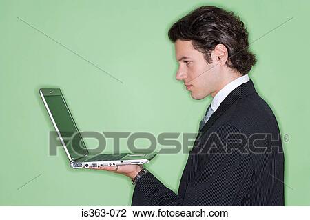 Businessman holding laptop View Large Photo Image Stock Image - Businessman holding laptop. Fotosearch