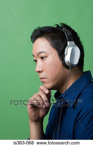 Man wearing headphones and thinking View Large Photo Image Stock Photo - Man wearing headphones and thinking. Fotosearch