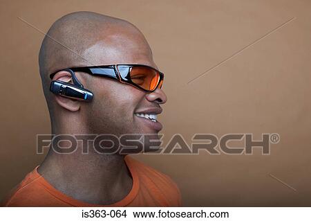 Picture - Man wearing sunglasses and headset. Fotosearch