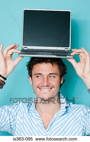 Man with laptop on his head View Large Photo Image Stock Photography - Man with laptop on his head. Fotosearch