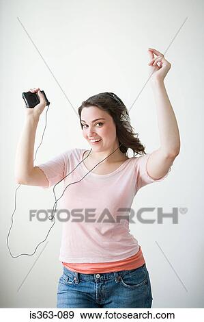 Stock Photo - Young woman listening to music. Fotosearch