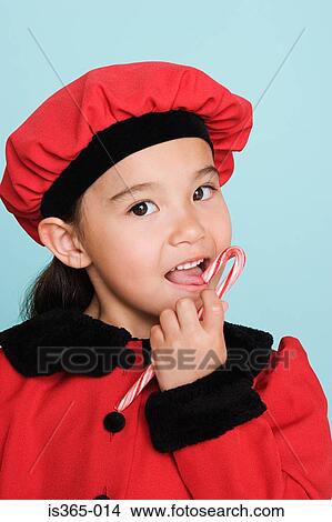 Girl eating candy cane View Large Photo Image Picture - Girl eating candy cane. Fotosearch
