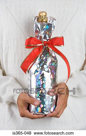 Man holding wrapped champagne bottle View Large Photo Image Stock Photo - Man holding wrapped champagne bottle. Fotosearch