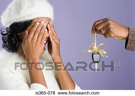 Man surprising woman with gift View Large Photo Image Stock Photo - Man surprising woman with gift. Fotosearch