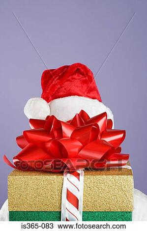 Stock Image - Person hiding behind presents. Fotosearch