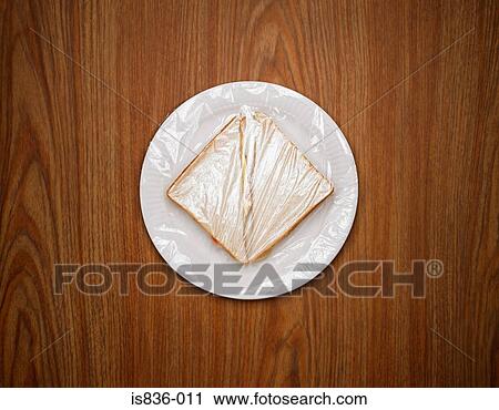 Stock Image - Sandwich on a plate wrapped in clingfilm. Fotosearch