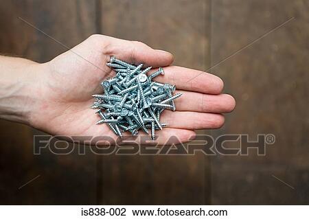 Stock Image - Person with screws in hand. Fotosearch