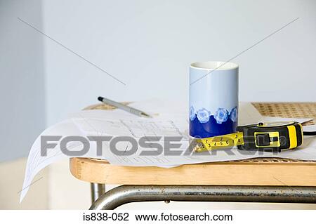 Plans on chair with tape measure and mug View Large Photo Image Stock Image - Plans on chair with tape measure and mug. Fotosearch