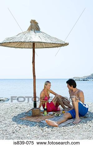 Stock Photography - Couple having a picnic by the sea. Fotosearch