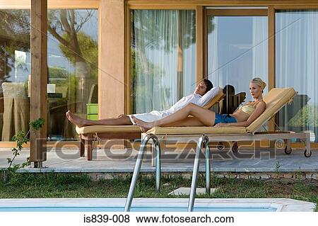 Couple on sunloungers View Large Photo Image Stock Photo - Couple on sunloungers. Fotosearch