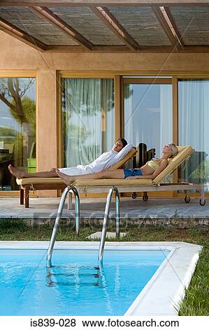 Stock Photo - Couple on sunloungers. Fotosearch