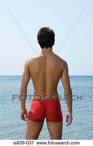 Man standing by the sea View Large Photo Image Stock Photo - Man standing by the sea. Fotosearch