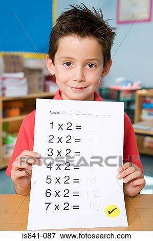 Stock Photo - Boy holding exam paper. Fotosearch