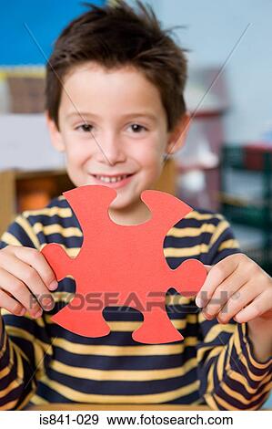 Stock Photo - Boy holding jigsaw piece. Fotosearch