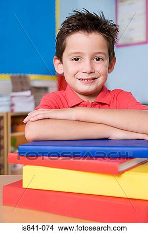 Boy leaning on stack of books View Large Photo Image Picture - Boy leaning on stack of books. Fotosearch